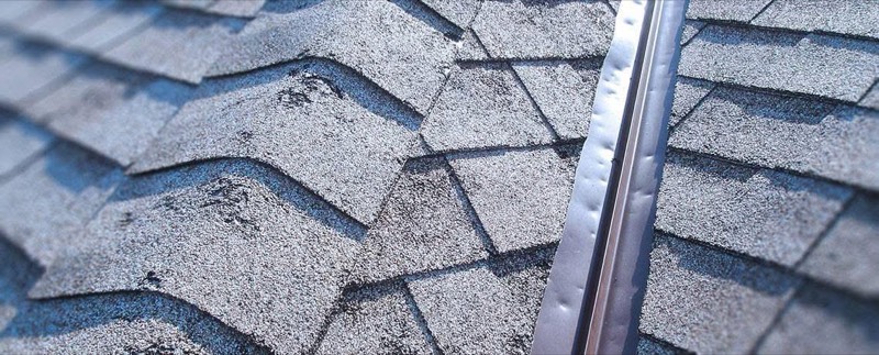 Iowa homeowner inspecting hail damage on a roof